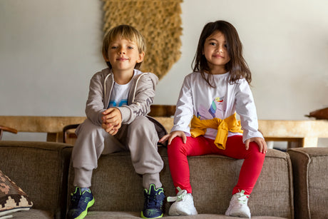Two kids sitting on sofa wearing CM Garmindo manufactured leisurewear.